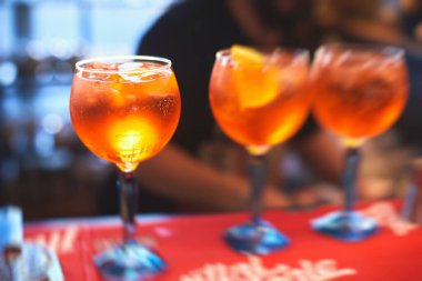 Sıra sıra kırmızı renkli negroni ve spritz aperatif alkollü kokteyller yemek masası, votka ve dekore edilmiş yemek masası etkinliği üzerine alkol seti. 