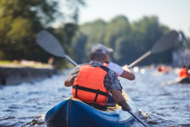 Şehir nehir kanallarında renkli kano kano kayığı kürek çekme, kano kullanma, yaz günü bir grup kano gezisi.
