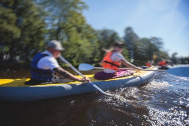 Şehir nehir kanallarında renkli kano kano kayığı kürek çekme, kano kullanma, yaz günü bir grup kano gezisi.