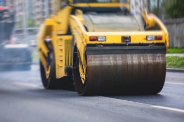 Yol yapımı sırasında asfalt kaldırım makinesi ve buharlı yol silindiri ve tamirat çalışmaları, asfaltlama ve asfalt döşeme süreci, yeni yol inşaatında çalışan işçiler