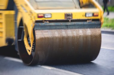 Yol yapımı sırasında asfalt kaldırım makinesi ve buharlı yol silindiri ve tamirat çalışmaları, asfaltlama ve asfalt döşeme süreci, yeni yol inşaatında çalışan işçiler