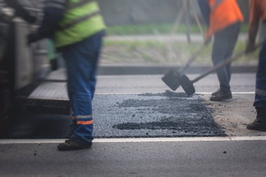 Yol yapımı sırasında asfalt kaldırım makinesi ve buharlı yol silindiri ve tamirat çalışmaları, asfaltlama ve asfalt döşeme süreci, yeni yol inşaatında çalışan işçiler