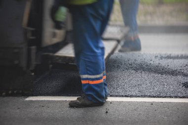 Yol yapımı sırasında asfalt kaldırım makinesi ve buharlı yol silindiri ve tamirat çalışmaları, asfaltlama ve asfalt döşeme süreci, yeni yol inşaatında çalışan işçiler