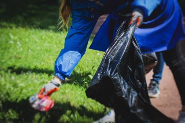 Gençler, kızlar ve oğlanlar gönüllü olarak toplum temizliğine katılıyor, aktivistler şehir parkında çöp, çöp, çöp ve çöp topluyor.