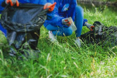 Gençler, kızlar ve oğlanlar gönüllü olarak toplum temizliğine katılıyor, aktivistler şehir parkında çöp, çöp, çöp ve çöp topluyor.