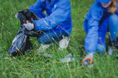 Gençler, kızlar ve oğlanlar gönüllü olarak toplum temizliğine katılıyor, aktivistler şehir parkında çöp, çöp, çöp ve çöp topluyor.