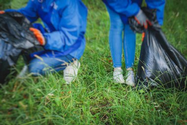 Gençler, kızlar ve oğlanlar gönüllü olarak toplum temizliğine katılıyor, aktivistler şehir parkında çöp, çöp, çöp ve çöp topluyor.
