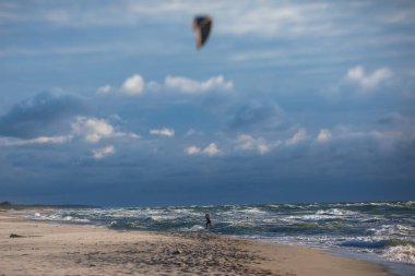 Profesyonel uçurtma sörfçüsü sörfçü sörfçü açık denizde dalgalarda yüzer, su sıçratır, uçurtma uçurur, uçurtma sörfü yapar yaz günü aşırı eğlenceli su sporları yapar.