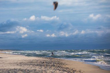 Profesyonel uçurtma sörfçüsü sörfçü sörfçü açık denizde dalgalarda yüzer, su sıçratır, uçurtma uçurur, uçurtma sörfü yapar yaz günü aşırı eğlenceli su sporları yapar.