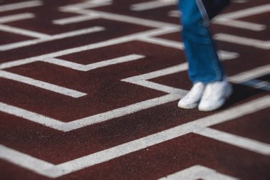 Labirent labirentinden kaçış ve çıkış yolu bulmaya çalışan bir insan ayağı görüntüsü, soruna çözüm bulma kavramı 