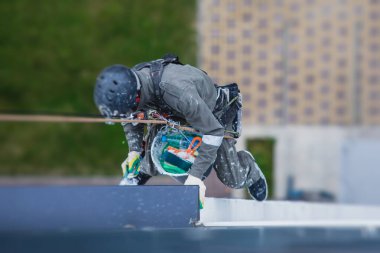 Profesyonel dağcı halat ulaşım işçisi boyama ve dış cephe duvarının dış cephesini onarma, yükseklerde çalışan endüstriyel dağcı, yüksek riskli jo