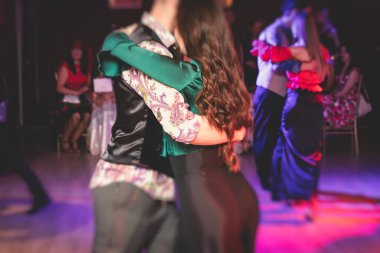 Balo salonunda geleneksel Latin dansı milongası yapan çiftler, kırmızı ışıklarda tango salsa dersi, dans festivali