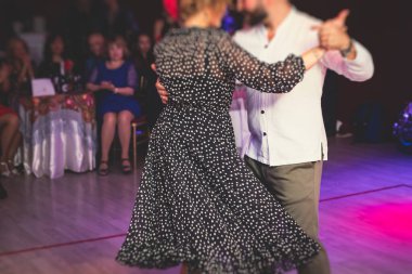 Balo salonunda geleneksel Latin dansı milongası yapan çiftler, kırmızı ışıklarda tango salsa dersi, dans festivali