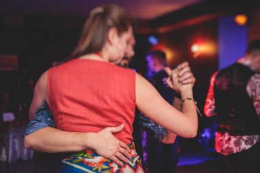 Balo salonunda geleneksel Latin dansı milongası yapan çiftler, kırmızı ışıklarda tango salsa dersi, dans festivali