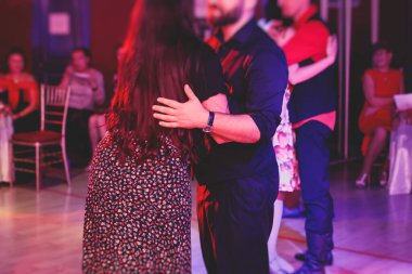 Balo salonunda geleneksel Latin dansı milongası yapan çiftler, kırmızı ışıklarda tango salsa dersi, dans festivali
