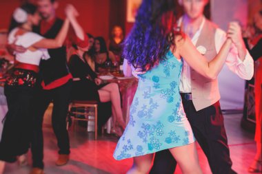 Balo salonunda geleneksel Latin dansı milongası yapan çiftler, kırmızı ışıklarda tango salsa dersi, dans festivali