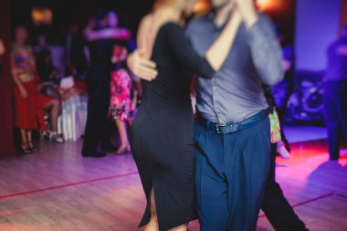 Balo salonunda geleneksel Latin dansı milongası yapan çiftler, kırmızı ışıklarda tango salsa dersi, dans festivali