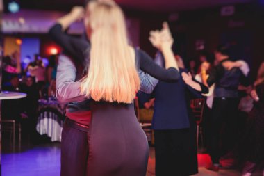 Balo salonunda geleneksel Latin dansı milongası yapan çiftler, kırmızı ışıklarda tango salsa dersi, dans festivali