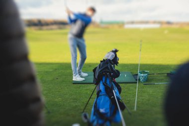 Golf antrenmanında antrenman yapan ve antrenman yapan bir grup golfçü, golf sahasında oynayan erkekler, golf klübünde golf oynayan erkekler, yaz güneşli da.