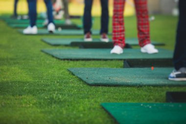 Golf antrenmanında antrenman yapan ve antrenman yapan bir grup golfçü, golf sahasında oynayan erkekler, golf klübünde golf oynayan erkekler, yaz güneşli da.