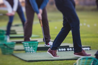 Golf antrenmanında antrenman yapan ve antrenman yapan bir grup golfçü, golf sahasında oynayan erkekler, golf klübünde golf oynayan erkekler, yaz güneşli da.