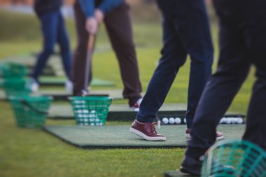 Golf antrenmanında antrenman yapan ve antrenman yapan bir grup golfçü, golf sahasında oynayan erkekler, golf klübünde golf oynayan erkekler, yaz güneşli da.
