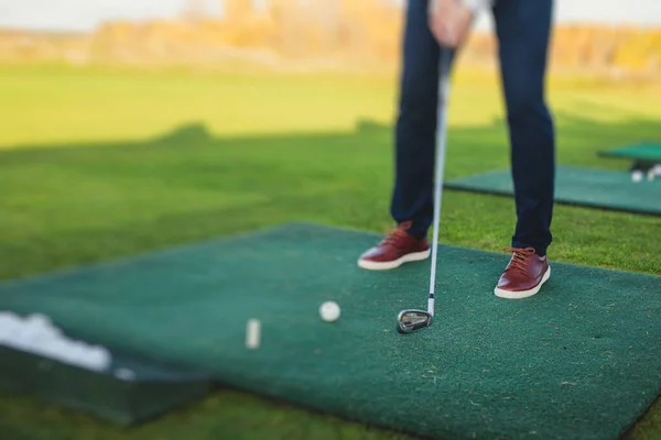 Group of golfers practicing and training golf swing on driving range practice, men playing on golf course, golf ball at golfing complex club resort, summer sunny da