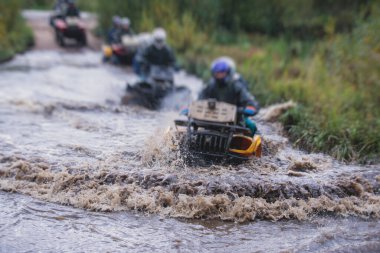 ATV aracını off road yolunda süren bir grup sürücü, ATV aracını sürme süreci, tüm arazi motorlu aracı, off-road yarışması sırasında, mu mu 'yu geçerken,