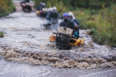 ATV aracını off road yolunda süren bir grup sürücü, ATV aracını sürme süreci, tüm arazi motorlu aracı, off-road yarışması sırasında, mu mu 'yu geçerken,