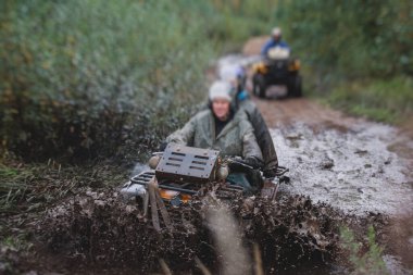ATV aracını off road yolunda süren bir grup sürücü, ATV aracını sürme süreci, tüm arazi motorlu aracı, off-road yarışması sırasında, mu mu 'yu geçerken,