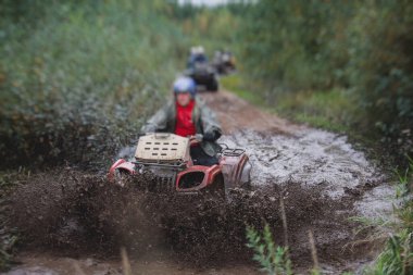 ATV aracını off road yolunda süren bir grup sürücü, ATV aracını sürme süreci, tüm arazi motorlu aracı, off-road yarışması sırasında, mu mu 'yu geçerken,