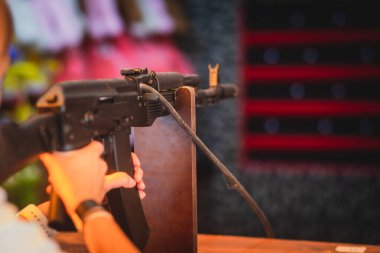 İnsanlar lunaparktaki atış poligonuna nişan alıp ateş ediyorlar. 