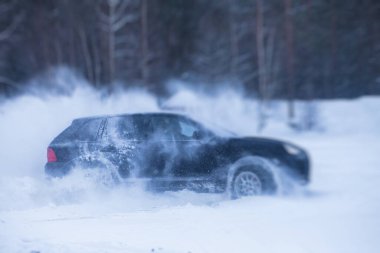 Kar ve buzda sürüklenen SUV arabası, yarışma sırasında, kışın karlı yarış pistinde sürükleniyor.