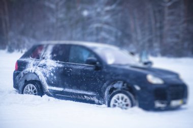 Kar ve buzda sürüklenen SUV arabası, yarışma sırasında, kışın karlı yarış pistinde sürükleniyor.