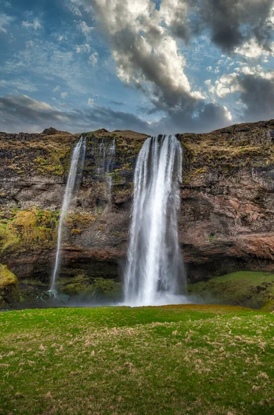 Seljalandsfoss Seljalandsfossはアイスランド南部に位置し 高速道路1号線からすぐです この滝のクールな点の1つは 訪問者が小さな洞窟にそれの後ろを歩くことができることです — ストック写真