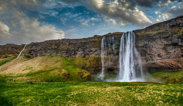 Seljalandsfoss Seljalandsfossはアイスランド南部に位置し 高速道路1号線からすぐです この滝のクールな点の1つは 訪問者が小さな洞窟にそれの後ろを歩くことができることです — ストック写真