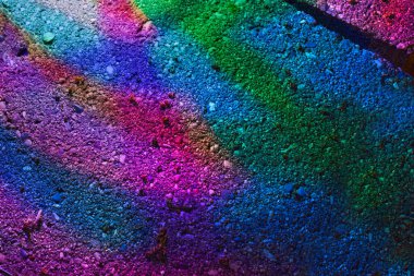 Yakındaki bir taşın üzerine düşen güneş ışığından gökkuşağının yakın çekimi..