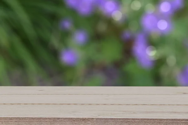 Weathered wood tabletop in front of a defocused flower garden background