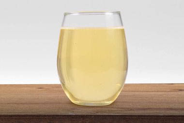 Köy kahvesi ahşap bir masanın tepesinde beyaz şarapla dolu Stemless şarap kadehi..