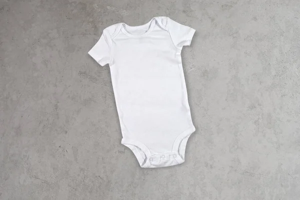 White Baby Bodysuit Resting Scandinavian Concrete Background — Stock Photo, Image