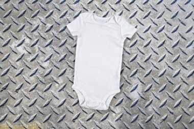 Yıpranmış metal bir arka planda beyaz tulumun yüksek açılı görüntüsü.