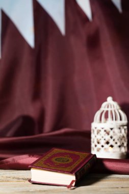Ahşap bir yüzey üzerinde kutsal kitabı Kur'an. Katar ve mum sahibi içinde belgili tanımlık geçmiş bayrağı