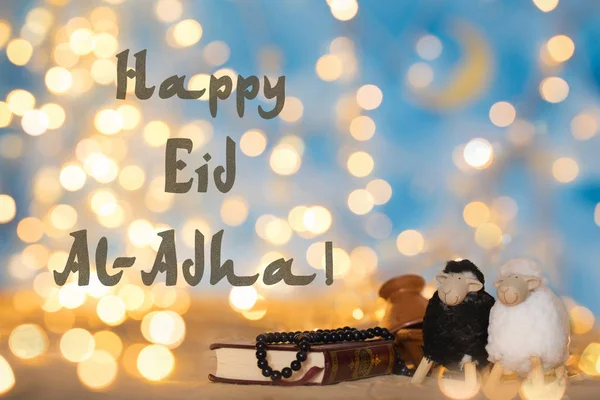 Mutlu Kurban Bayramı. Kur'an-ı Kerim, dua eden, küçük tagine, iki kuzu siyah beyaz boncuk. Çeviri-kitap Kur'an-ı Kerim ayet içerir