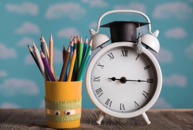 Okul malzemeleri ve vintage çalar saat ile kalem sahibi. Portre