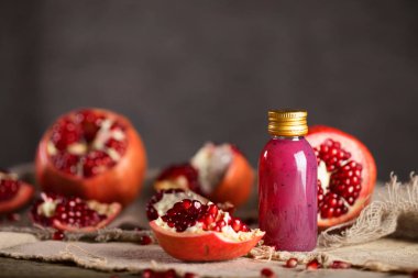 Glass of pomegranate seed body scrub on a wooden surface. Closeup clipart