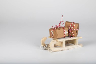 Noel ile küçük dekoratif ahşap kızak üzerinde gri bir arka plan sunuyor. Portre