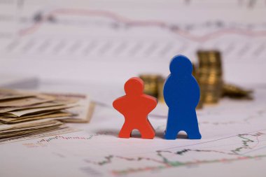 Ahşap figürler kırmızı ve mavi bir diyagram üzerinde. Para içinde belgili tanımlık geçmiş.