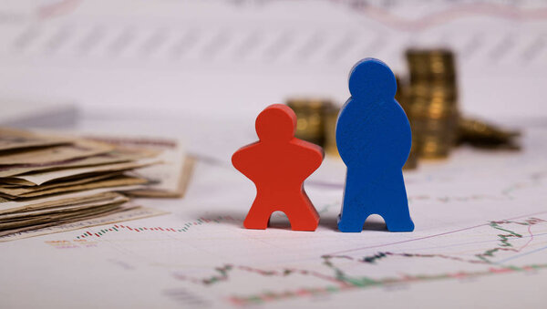 Wooden figurines in red and blue on a diagram. Coins in the background.