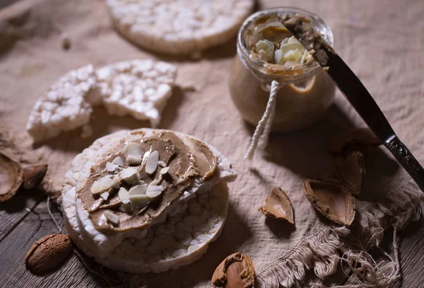 Домашнее миндальное масло на куске рисового хлеба . — стоковое фото