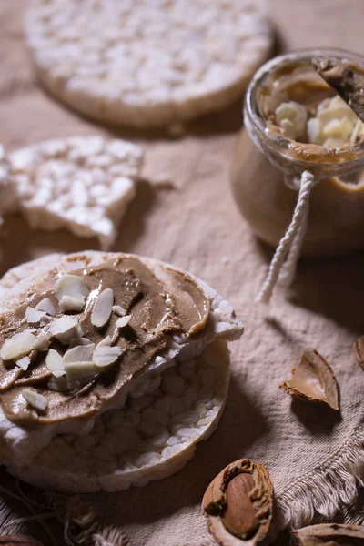 Mantequilla de almendras casera en una rebanada de pan crujiente de arroz . —  Fotos de Stock